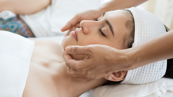 A therapist giving a facial massage