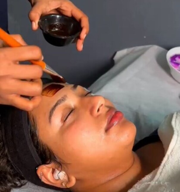 Oil being poured onto a guest's forehead